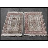 2 Islamic silk and wool machine woven prayer rugs, each with tassled ends having central mihrab.