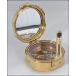 A brass cased compass and sundial set in a circular brass case with hinged cover,