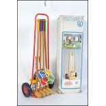 A retro 1980's croquet lawn set complete with boulle, within the original wheeled carrying holdall.