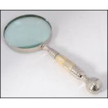 A large good quality silver plated and mother of pearl inset magnifying glass having finial end to