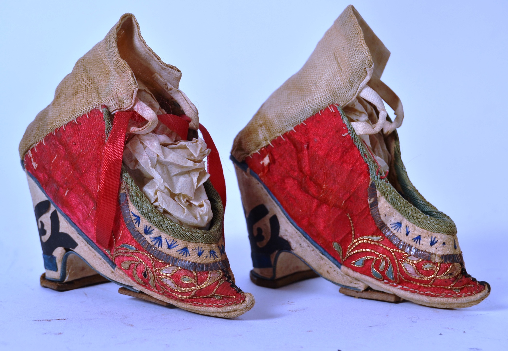 A pair of Chinese red silk and embroidered shoes with laces being handstitched, - Image 2 of 4