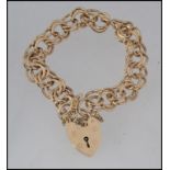 A 9ct gold double hoop link ladies bracelet and heart locket complete with safety chain being