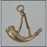 A gold unmarked gold fob watch winding key in the form of a hunting horn tests 9ct gold with hard