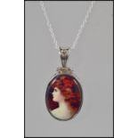 A ladies silver pendant necklace having inset enamel pictorial of a lady.