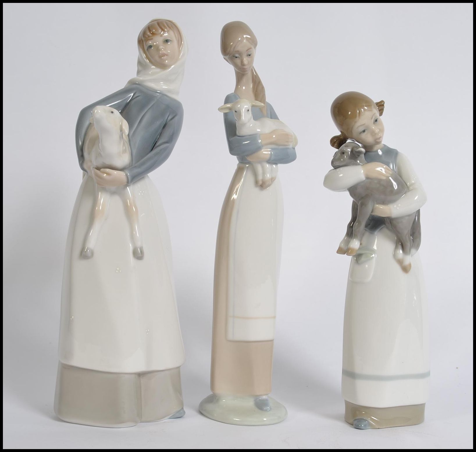 A collection of three Lladro porcelain figurines of young girls with animals,