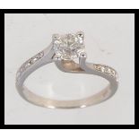 A contemporary tested 14ct white gold and diamond ladies ring having approx 75pnts stone to centre