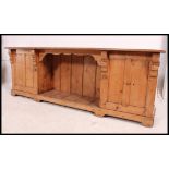 A Victorian pine low dresser base comprising end cupboards with central open recess shelf finished