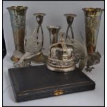 A collection of silver plate items to include a pair of matchin g vases in relief, candle sticks,