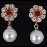 A cased pair of ladies freshwater pearl and cz adorned earrings having inset garnet stone centres.