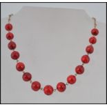 A vintage Art Deco cherry red bead necklace with rolled gold links and hook clasp in a vintage