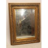 A large antique Victorian style gilt overmantel mirror dating to the 20th century having central