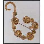 A 1940's gold tone brooch with set amber cabochon stones and closed peony flower heads on a scroll