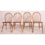 A set of 4 1970's Ercol golden dawn stick back dining chairs in beech and elm with saddle seats and