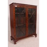 A Regency style mahogany bookcase display cabinet raised on bracket feet with twin astragal glazed