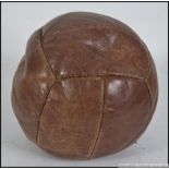 A circa early 20th century medicine ball - leather bound. Measures: 26cm.