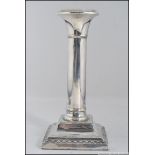 A silver hallmarked column candle stick raised on a square base having worn marks 209g Measures: