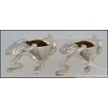 A pair of really heavy novelty silver plated salts in the form of frogs carrying baskets.