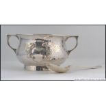 A silver hallmarked hammered Arts & Crafts twin handled sugar bowl ( plain cartouche ) and spoon.