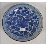 A 18th / 19th century blue and white delft dish of circular form having foliate central design.