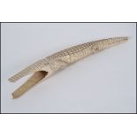 An early 20th century carved Ivory tusk in the form of a crocodile having scaled body with hollow