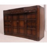 A 20th century Jacobean revival sideboard comprising short drawers over cupboards beneath having