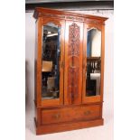 An Edwardian mahogany arts and crafts double wardrobe having plinth base with drawer and double