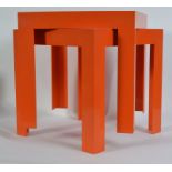 A pair of retro Kartell orange occasional tables of plastic form being raised on squared supports.