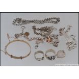 A collection of silver and silver metal items of jewellery to include bracelets, charm bracelet,