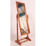 A 20th century pine cheval mirror raised on turned supports with splayed legs united by stretcher.