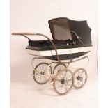 A large and good condition 1970's pram with the original green fabric body with white stripe having