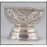 A silver Islamic finger bowl having mythical carp design on raised base,