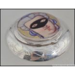 A silver embossed pill / snuff box with an applied pictorial enamel image of young maiden wearing a