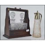 A contemporary tantalus in mahogany case with 2 decanters. Together with a silver plate claret jug.