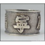A chinese silver napkin ring in the manner of Wang Hing having large character marks to the banded