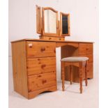 A 20th century antique style pine dressing table desk being raised on bun feet with pedestals of