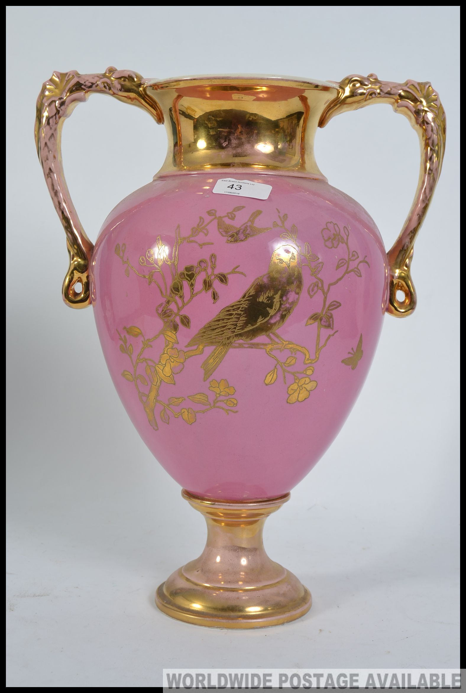 A large twin handled Victorian Staffordshire campana vase having pink ground with gilded details of