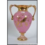 A large twin handled Victorian Staffordshire campana vase having pink ground with gilded details of