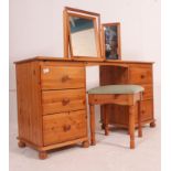 A 20th century antique style pine dressing table desk being raised on bun feet with pedestals of