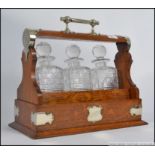 An early 20th century Creakes Patent silver plate and oak 3 piece decanter tantalus.