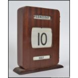 A vintage 1950's teak wood desk top calendar with rollers having the paper rollers intact.