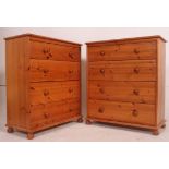 A pair of 20th century antique style pine chests of drawers being raised on bun feet with straight