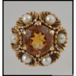 A 9ct gold Art Deco dress ring with central round cut citrine surrounded by scalloped set pearls in