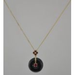 A hallmarked 9ct gold obsidian and ruby pendant necklace with obsidian disk set with a central ruby