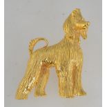 A vintage gold tone figural brooch in the form of an Afghan Hound dog with rhinestone eyes and