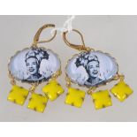 A pair of vintage drop earrings with yellow glass dangle with centrl pictorial cabochon of Carmen