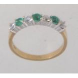 A hallmarked 9ct gold ring set with alternating green and clear stones. Hallmarked for Birmingham.