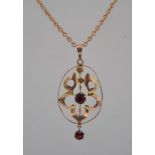 An Art Nouveau 9ct gold garnet drop pendant necklace with large pierced foliate pendant with