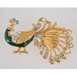 A vintage yellow metal enamelled figural brooch in the form of a peacock with with rhinestone and
