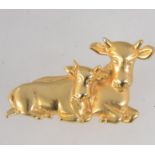 A vintage signed yellow metal figural brooch in the form of a cow and calf with roller clasp.