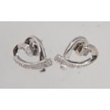 A pair of 9ct white gold and diamond earrings in a heart form with illusion set diamonds with post